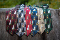 a variety of old man of the mountain New Hampshire neckties hanging from a tree branch
