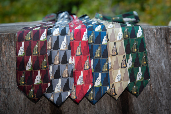 a variety of old man of the mountain New Hampshire neckties hanging from a tree branch